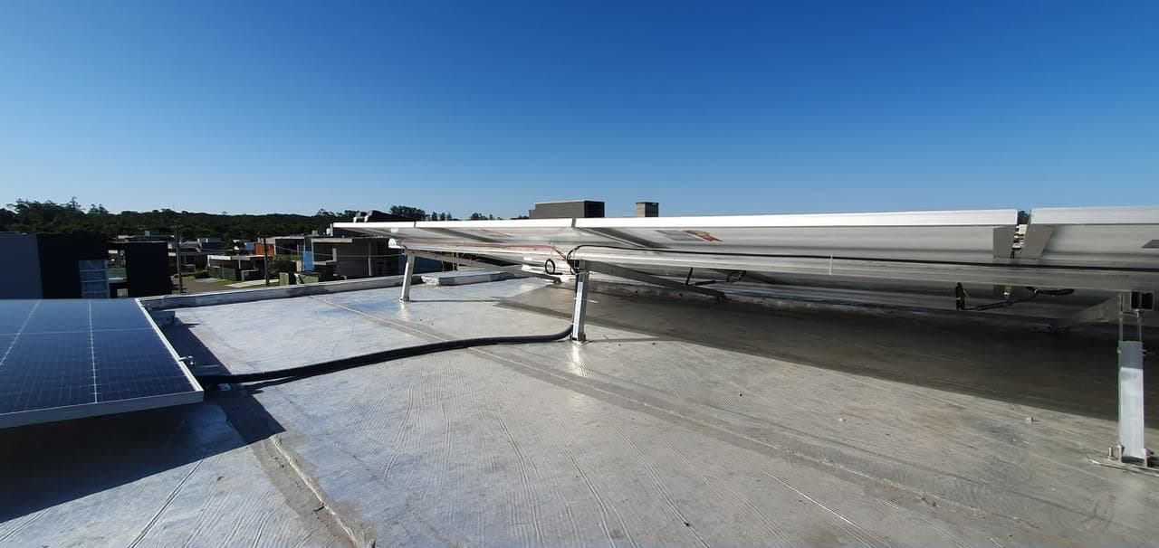 Estrutura traseira e cabeamento de painéis solares sobre uma cobertura